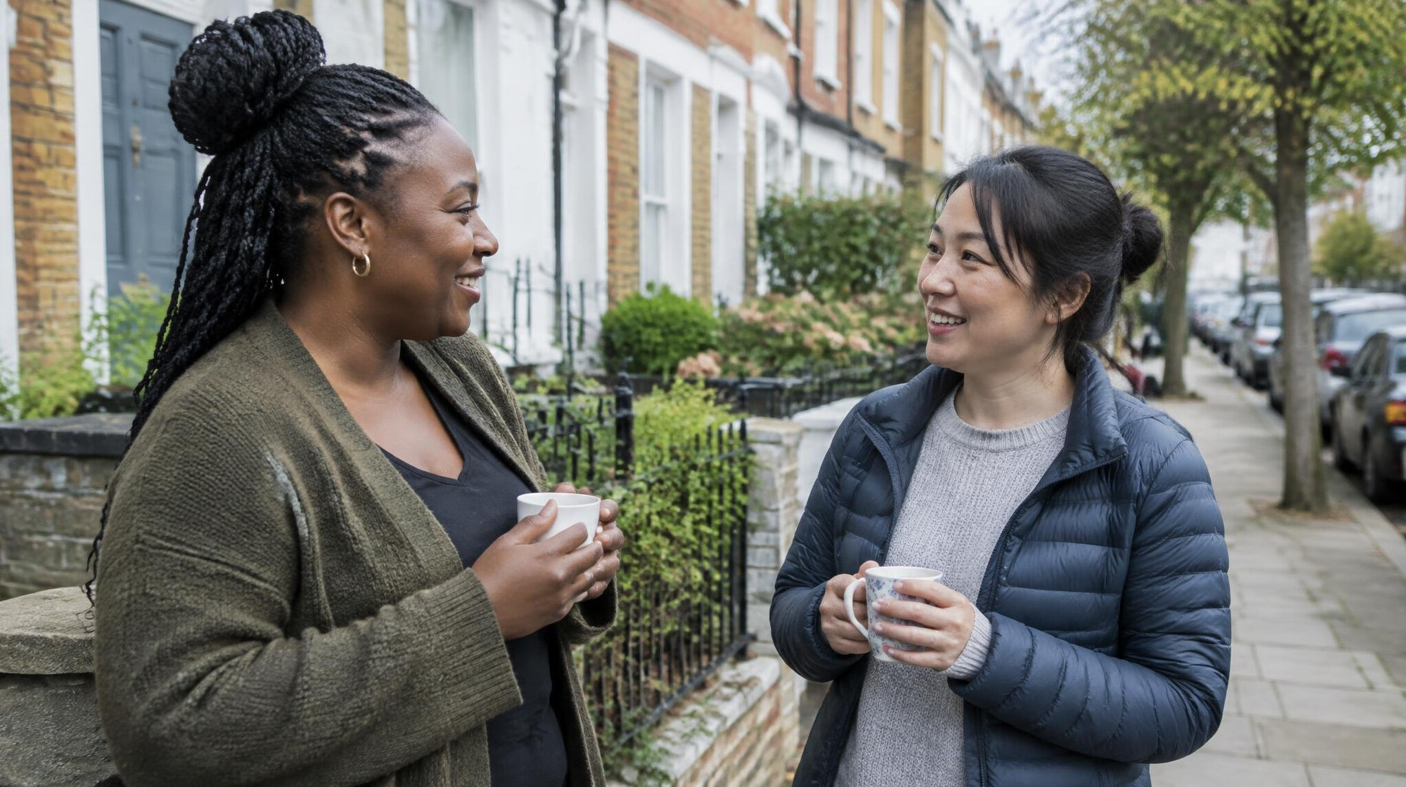 Neighbours chatting outside on a city sidewalk